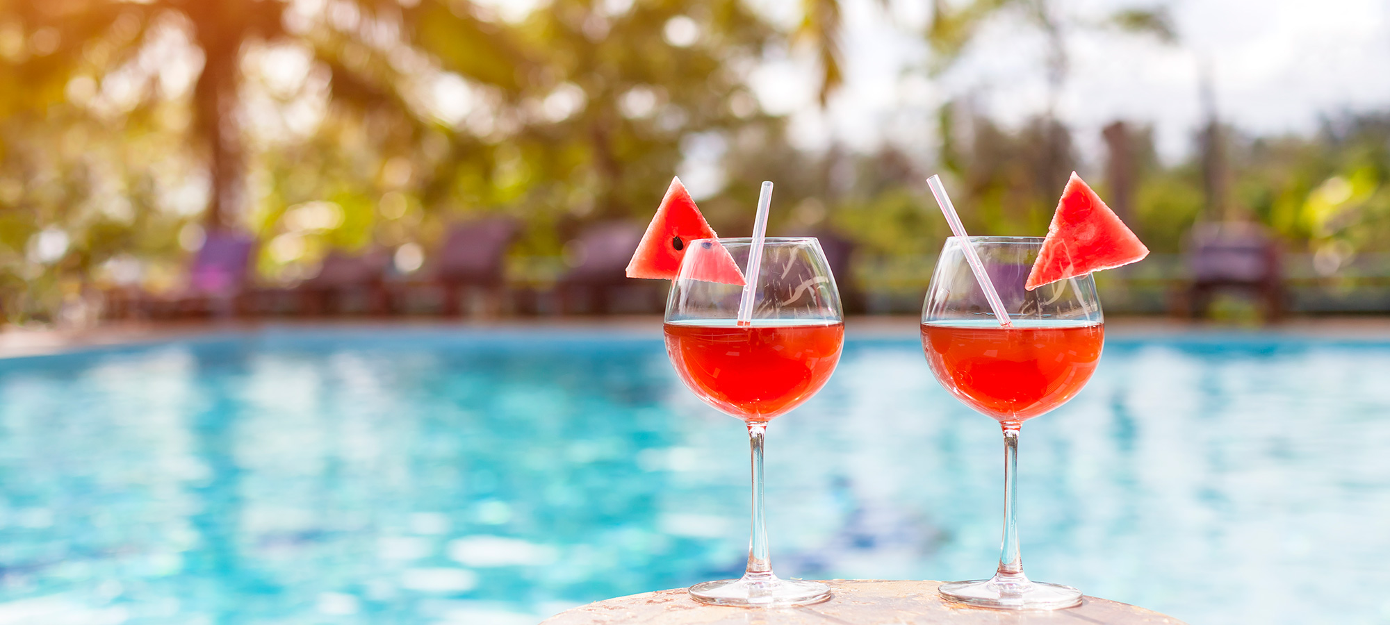 Two drinks sitting poolside