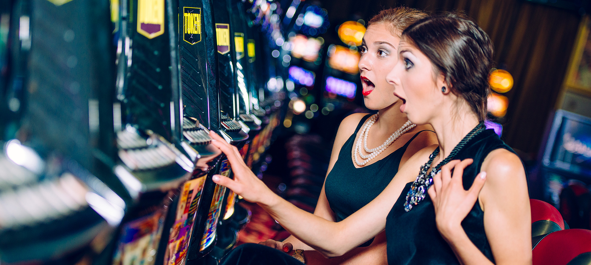 Two women playing a slot machine